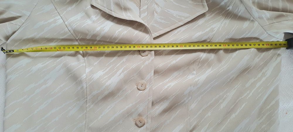 blazer feminino de cor bege com um padrão abstrato claro,