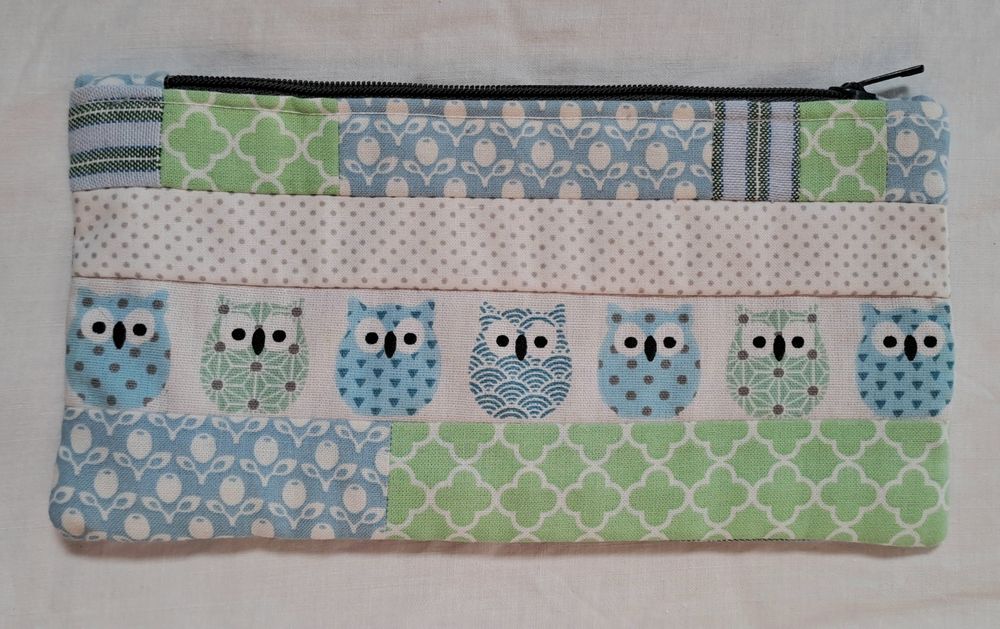 Estojo artesanal de patchwork com um padrão divertido com motivos de corujas em tons verdes, azuis e branco