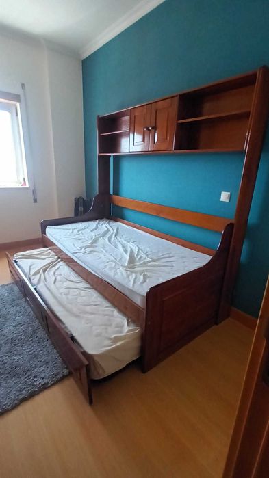 Estúdio em madeira, com estrados, colchões, gavetão e estante.