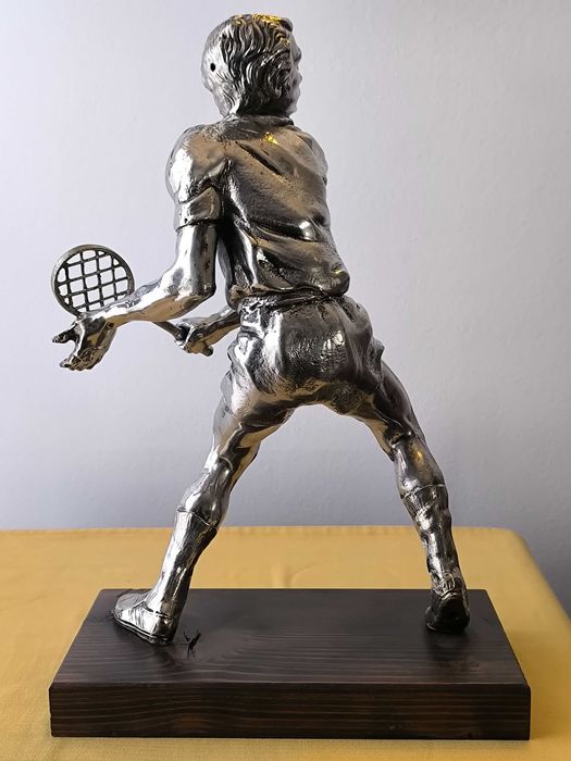 Escultura em metal prateado de jogador de ténis, com base em madeira