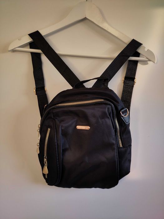 Mochila preta com detalhes dourados