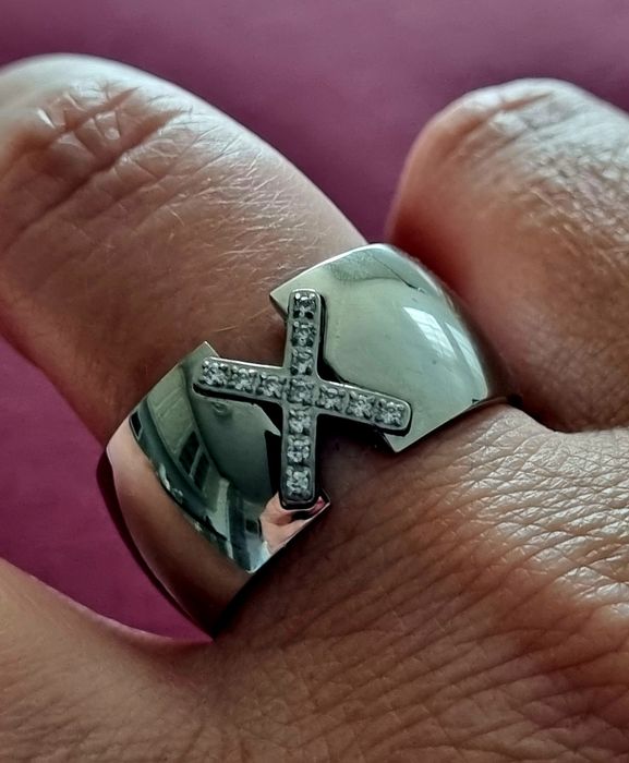 Anel grosso prateado, em aço, com um X em zirconias. T20