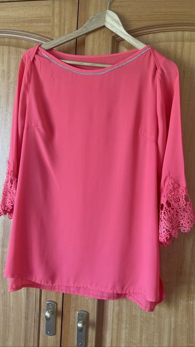 Blusa de senhora, na cor coral. Veste um L.