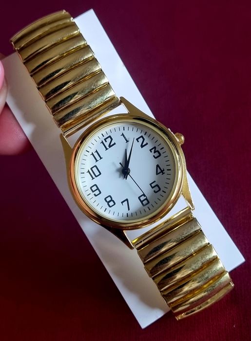 Relógio dourado, elástico, com mostrador em aço.