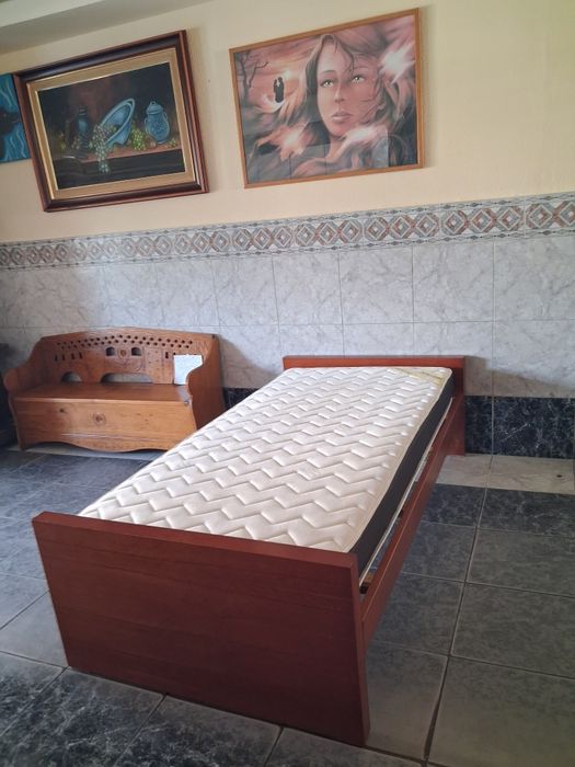 Cama de solteiro com estrado e colchão.
