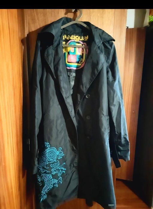 Gabardina preta e impermeável.
