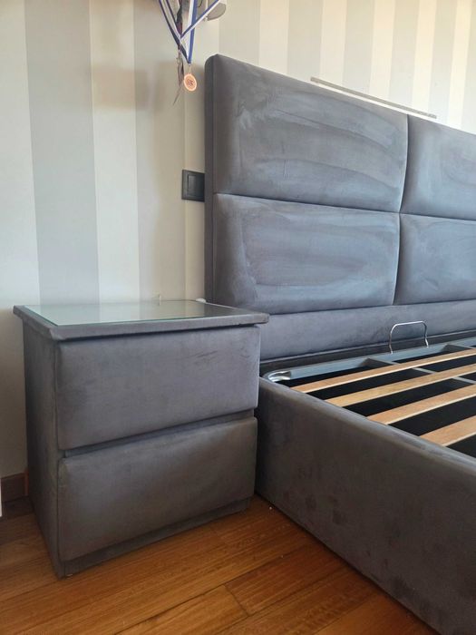 Cama de casal estufada com duas mesas de cabeceira
