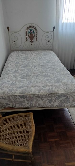 Cama de ferro e mesinha de cabeceira