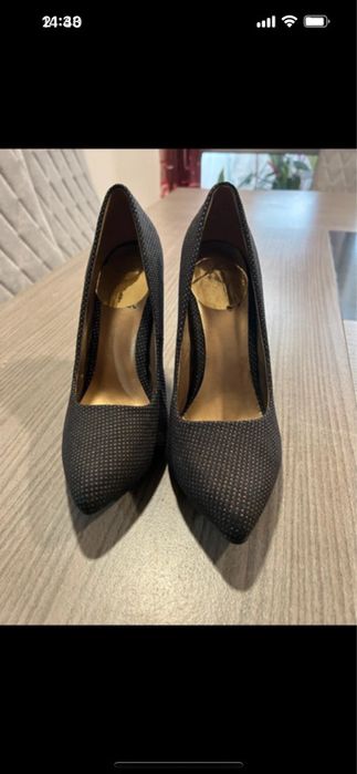 Sapatos de salto alto pretos com padrão brilhante dourado.
