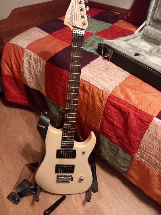Guitarra eléctrica em caixa com suporte e amplificador