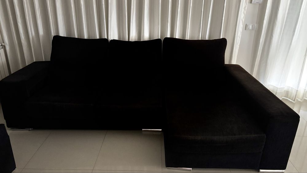 Sofá preto com chaise longue e arrumos