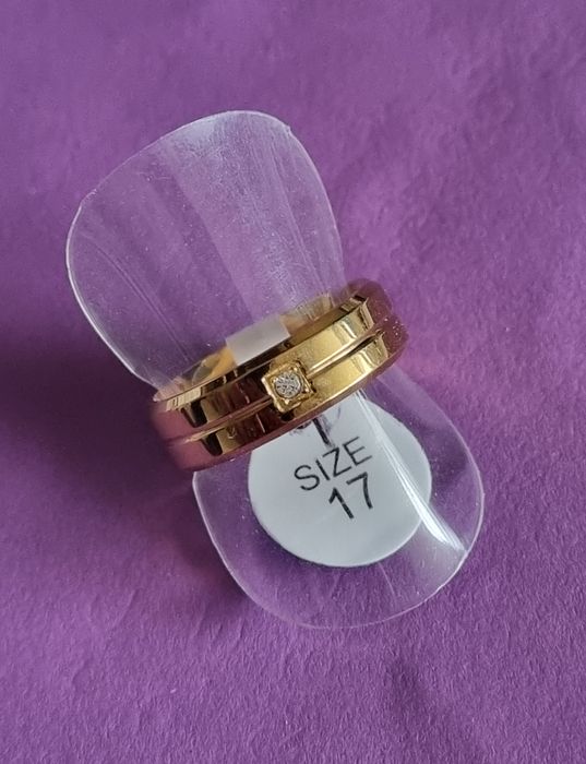 Anel/aliança dourado, em aço inoxidável, com 1 brilhante. T17