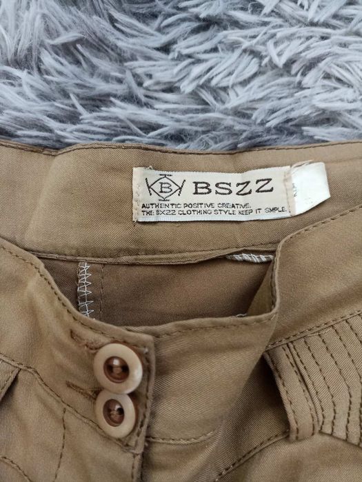 Жіночі брюки гірчичного кольору.