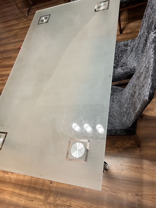 Szklany stół z metalowymi nogami