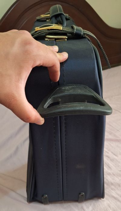 Mala de viagem azul com detalhes dourados