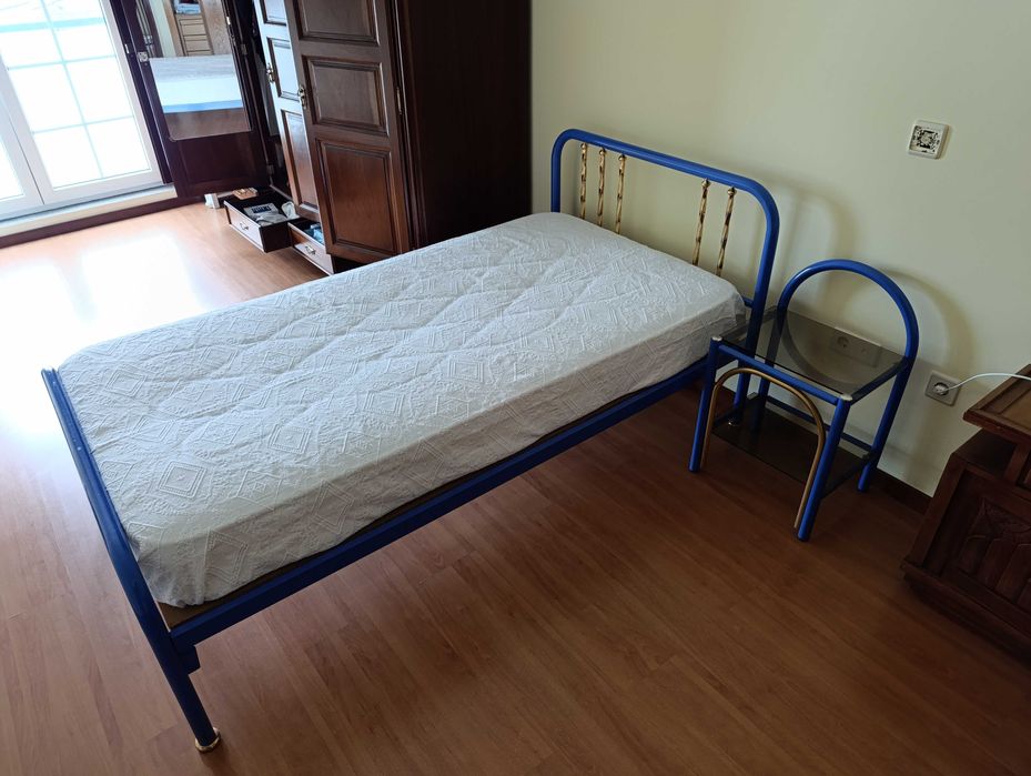 Cama solteiro azul e mesa de cabeceira