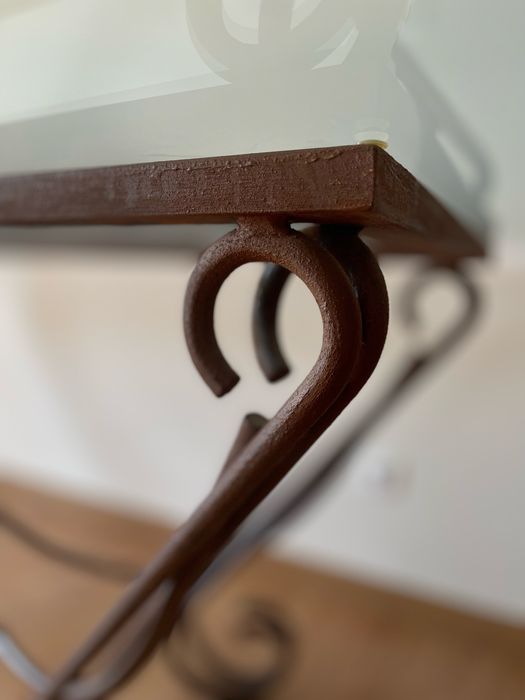 Mesa de jantar com tampo em vidro e base em ferro forjado