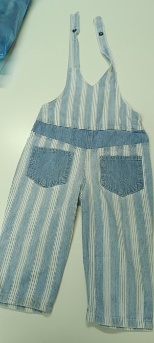 Calças jardineiras de criança