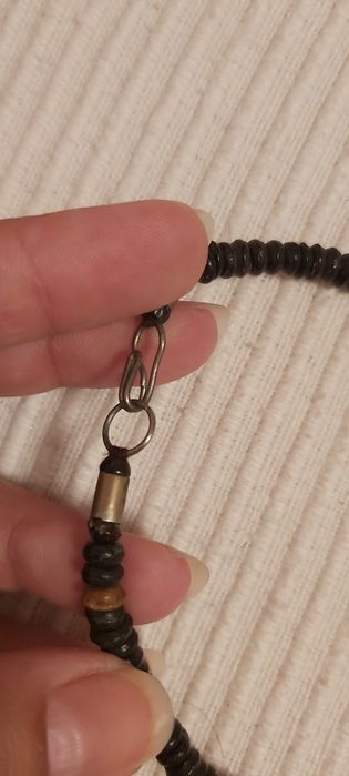 Vários colares de praia feitos de sementes polidas e outros materiais