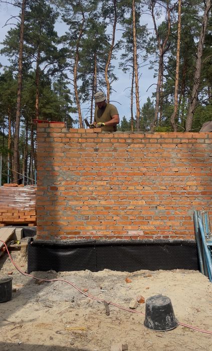 Бригада будівельників. Будівництво будинків. Мурування цегли