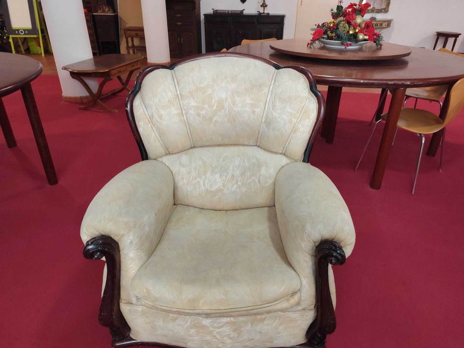 Duas poltronas clássicas para sala de estar, com estofado em tecido claro e estrutura em madeira escura.