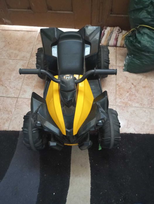 Moto quatro a bateria e uma pista de carro iluminosa praticamente nova