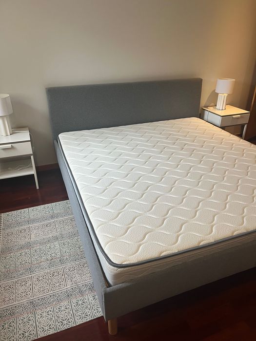Cama king size cinzenta com pernas de madeira