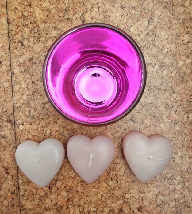 Copo em tons de rosa com três velas em formato de coração