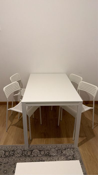 Mesa branca com 4 cadeiras brancas