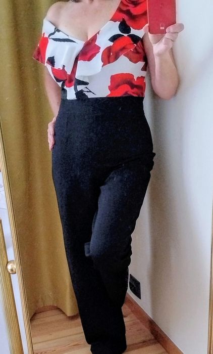 Wizytowy kombinezon z długa szeroką nogawką, dekolt z falbaną