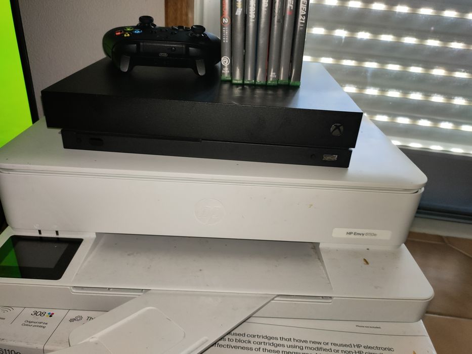 Xbox One X com jogos e headphone