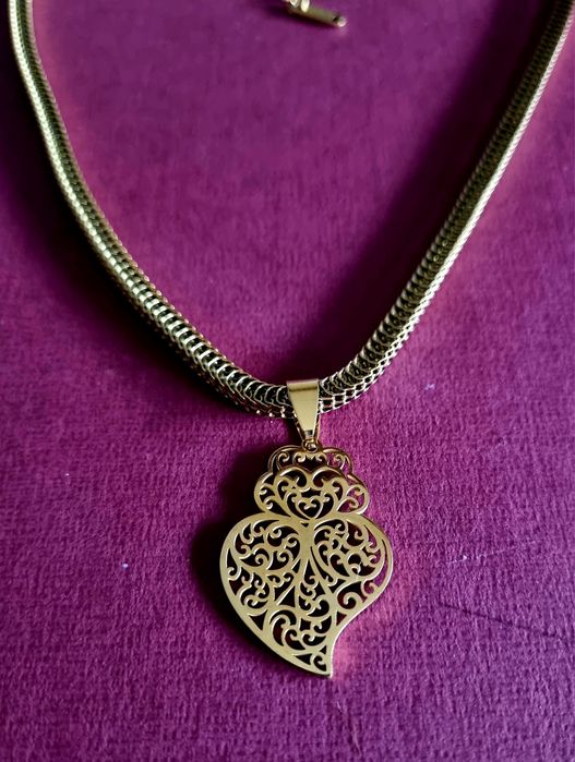 Colar dourado, em aço, malha grossa e um coração de Viana em filigrana