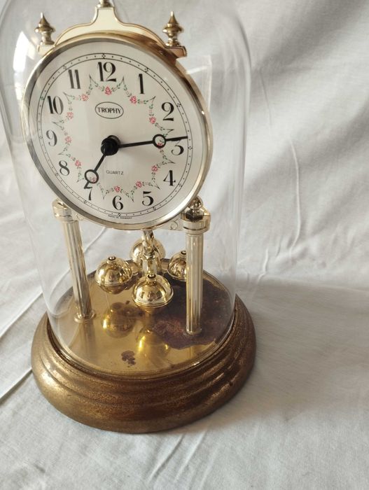 Relógio vintage de mesa sob cúpula de vidro, está a funcionar