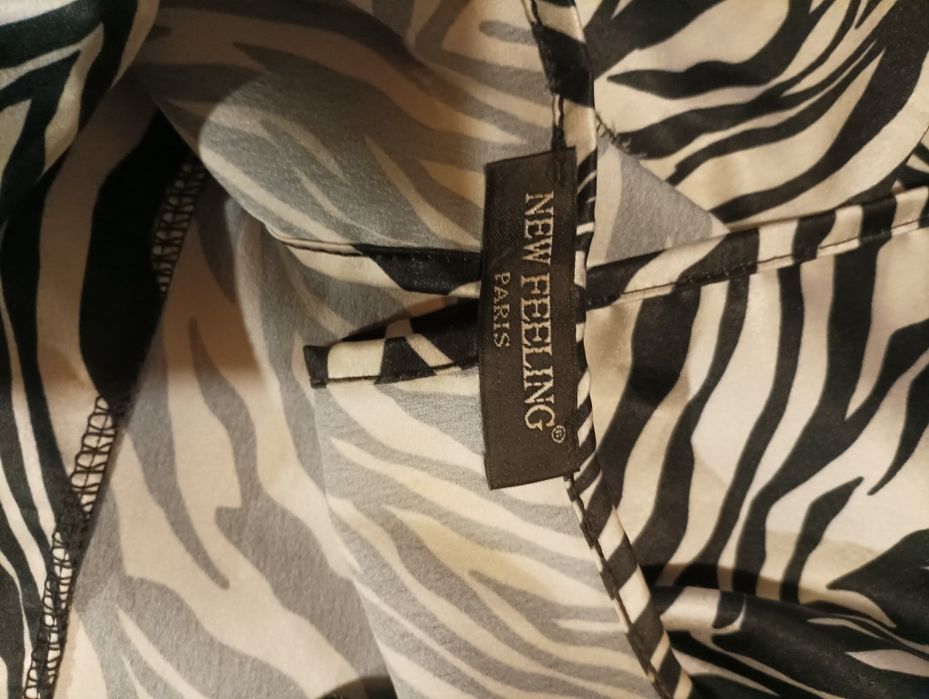 Top em branco e preto, com mangas largas, aperta atrás com um laço,de marca New Feeling, tamanho M