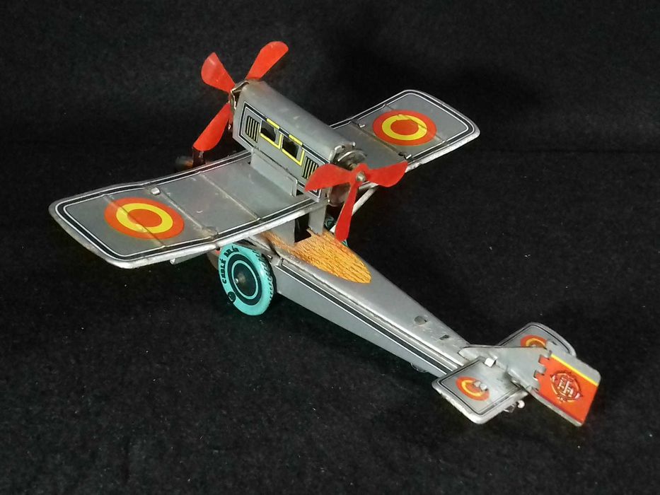Miniatura de avião antigo em metal, com sistema mecânico de corda;