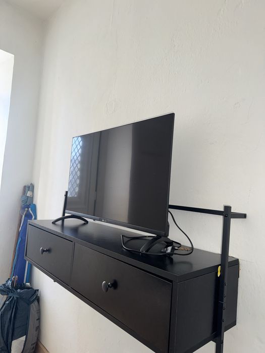 Estante preta pendurada para tv