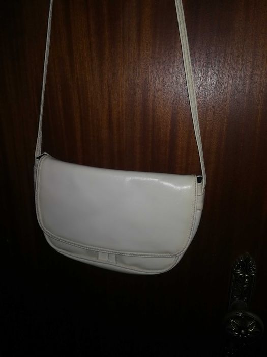 Mala branca, pequena, com alça comprida, dá para pôr ao pescoço.
