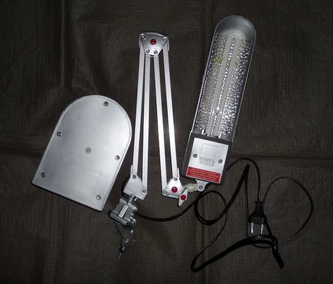 Лампа люминесцентная серебристая. На струбцине и на подставке.