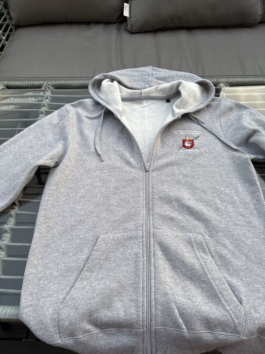 szarą, sportową bluzę rozpinaną z kapturem, logo szkoły w Mostach