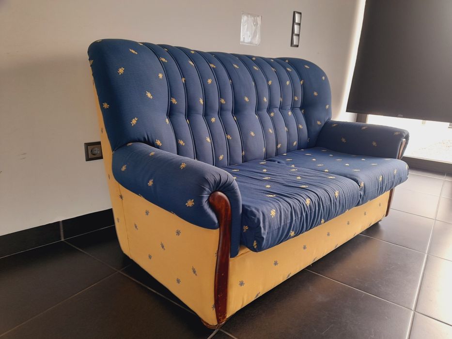 Sofá usado, mas ainda confortável e em bom estado. Com estampado azul