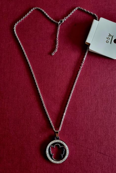 Colar prateado, em aço, pingente de anjinho rodeado de zirconias