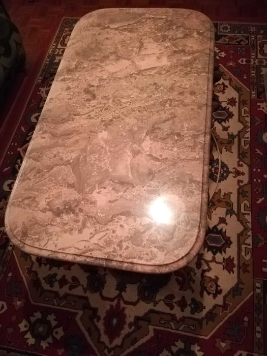 Mesa de centro com tampo em mármore e pés trabalhados