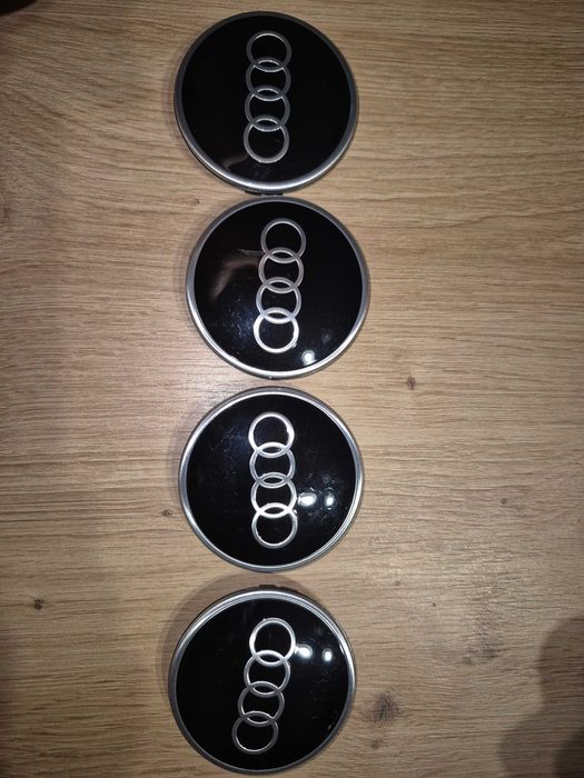 Dekielki Audi 81A601170A 81A601170 czarne połysk 4 szt Oryginalne dekl
