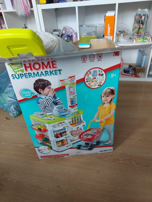 Sklep market zabawkowy, kasa, półki, koszyczki.