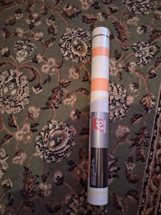 Rolka tapety w pasy pomarańczowe.