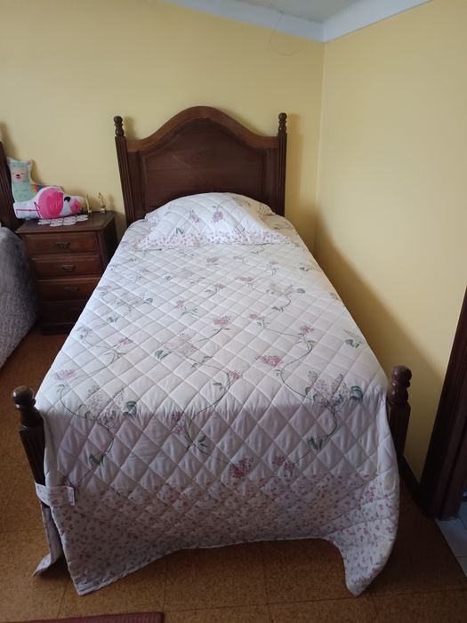 Uma cómoda um armário uma mesa de cabeceira e duas camas