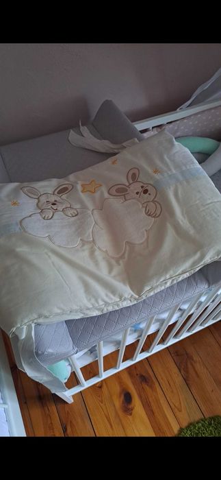 Solidne, białe łóżeczko dziecięce z baldachem.