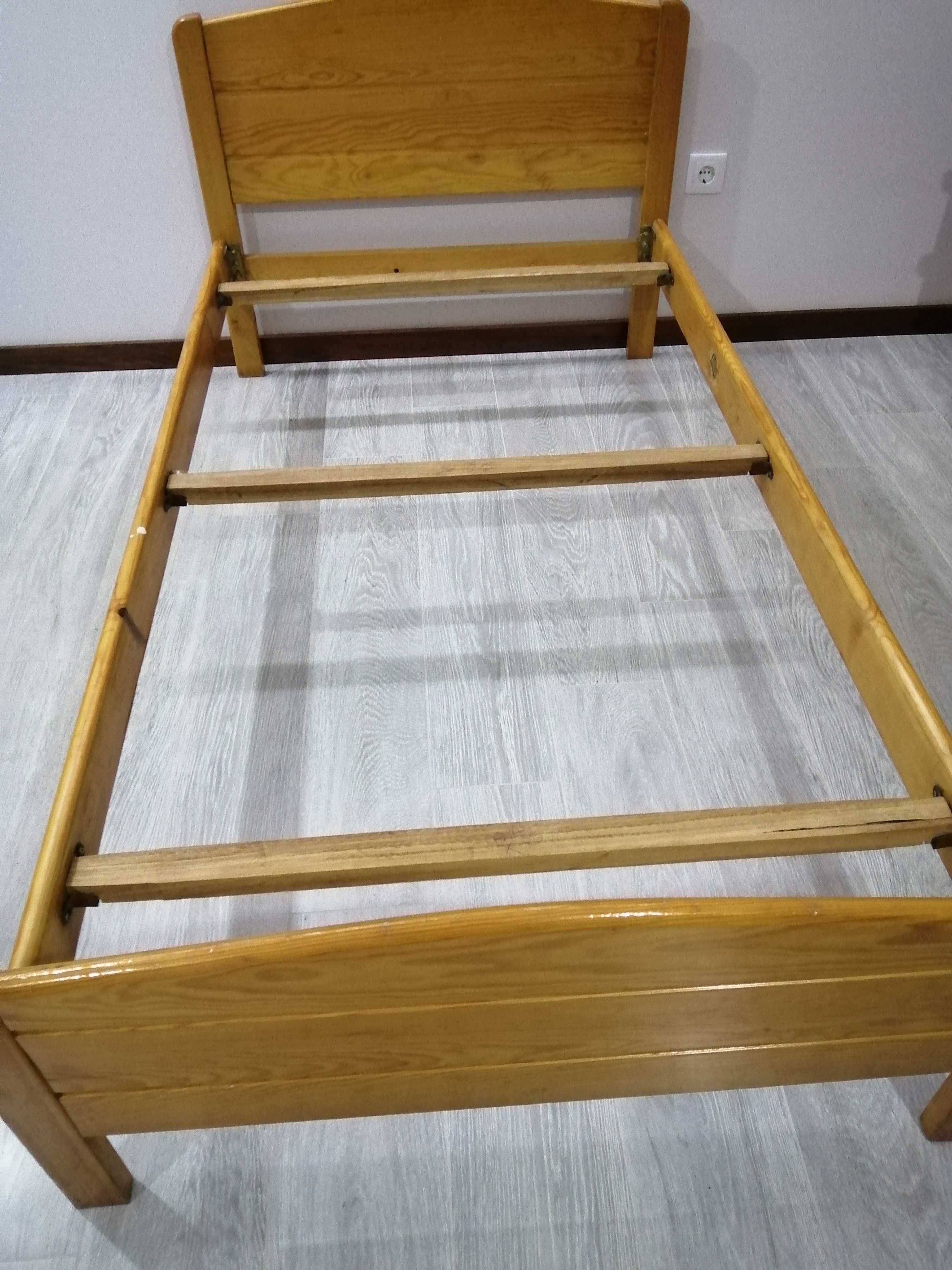 Cama de solteiro com mesinha de cabeceira.