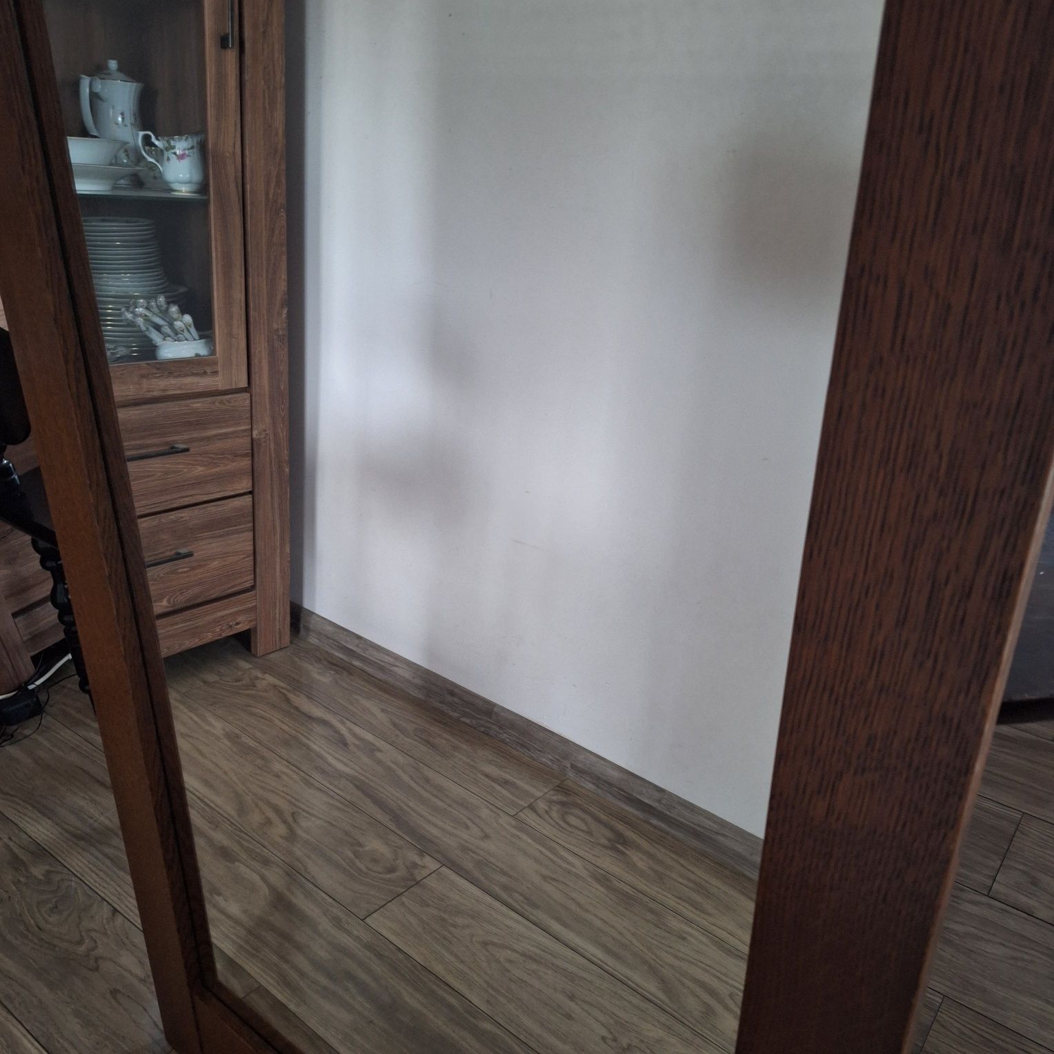 Duże lustro w ciemnobrązowej drewnianej ramie
