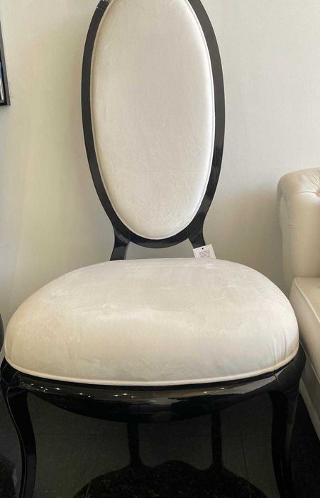 Cadeira elegante em veludo branco com estrutura preta de exposição